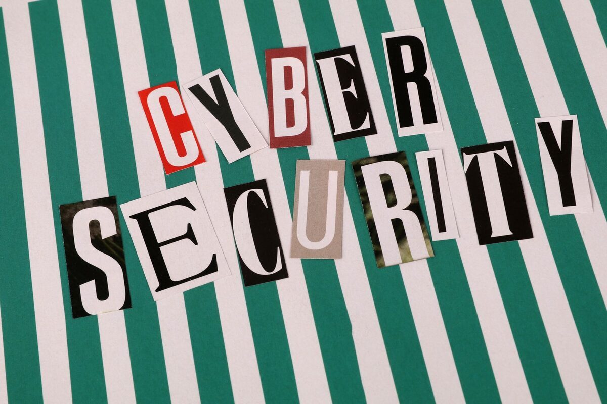 napis CYBER SECURITY ułożony z wyciętych liter na paskowanym tle — Laptop HP zalany – procedura ratunkowa (pierwsze kroki) w laptopie HP — co wpływa na koszt naprawy